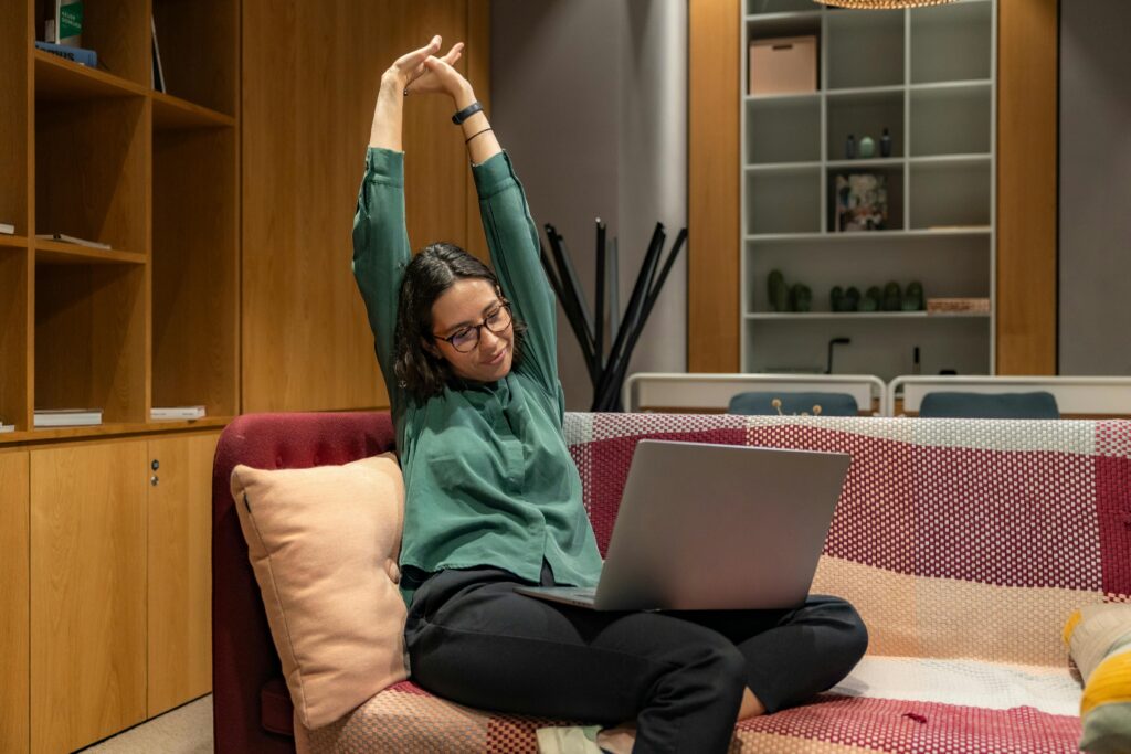 pexels photo 18955784 18955784 A woman relaxes while working from home on a sofa, showcasing a flexible work environment.