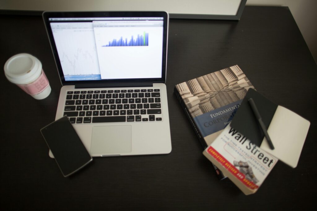 pexels photo 259091 259091 Top view of a desk with laptop, charts, books, and coffee, depicting a modern financial workspace setup.