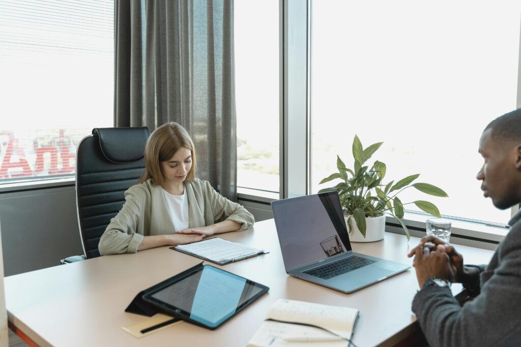 pexels photo 5439138 5439138 A diverse job interview scenario in a modern office setting with a laptop and documents on the table.